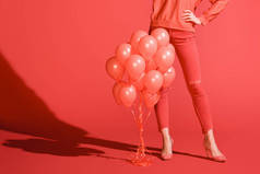 裁剪的女孩摆在与活珊瑚气球的时尚女孩的看法。2019年的潘通颜色概念