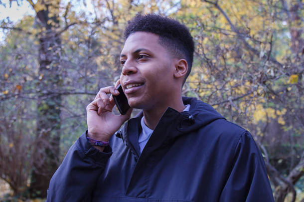 浅谈智能手机在森林里的黑人青年.