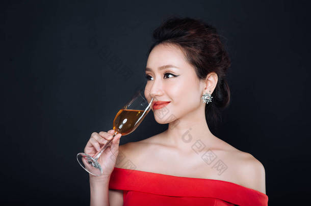 年轻的亚裔女子豪华红裙与玻璃的起泡酒。党、 饮料、 节日和庆祝的概念.