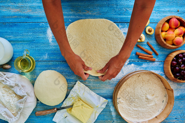 Young girl chef kneads  and rolling the dough with pin