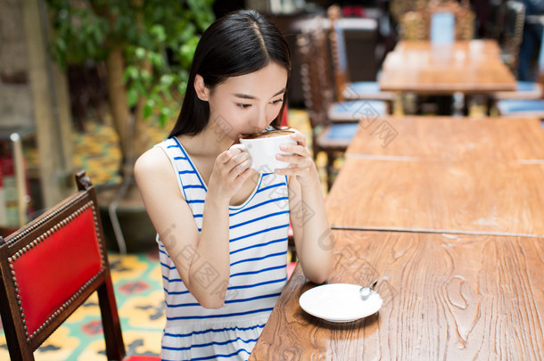 年轻漂亮的女人喝咖啡