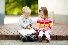 可爱的男孩和女孩读一本书
