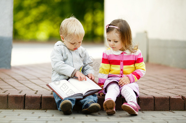 可爱<strong>的</strong>男孩和女孩读一本书