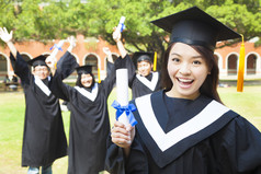 拿着文凭与朋友的快乐的大学毕业生