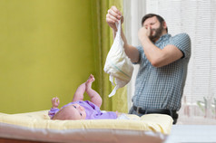 婴儿护理概念。父亲 od 爸爸换臭尿布.