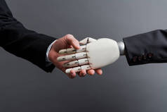 商人与孤立于灰色进化概念之外的机器人握手的剪影 