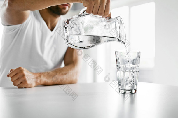 喝水。特写人把水倒进玻璃里。水化