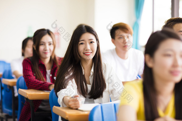 微笑着坐在一起的同学的女大学生