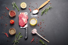 生牛肉牛排，放在切刀上。为烹饪牛排准备的生牛肉。除了烹饪牛排、香料和香草的配料.