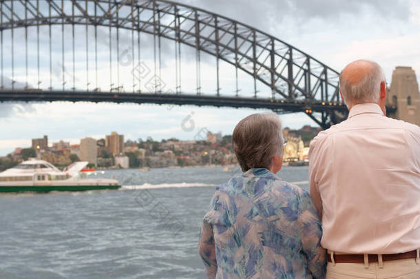 老夫妇在多云的午后欣赏悉尼海港大桥景观.