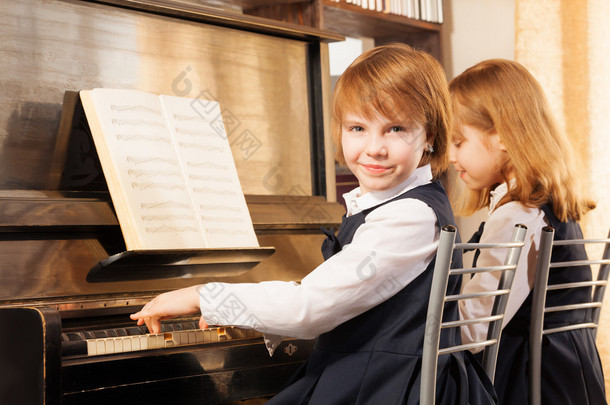 两个漂亮的女孩弹钢琴