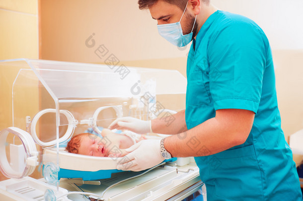 医护人员<strong>照顾</strong>刚出生的婴儿在婴儿培养箱