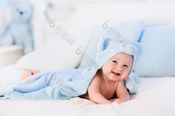 小男孩在蓝色毛巾在白色床上