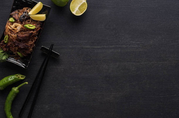 黑色背景下的筷子和配料