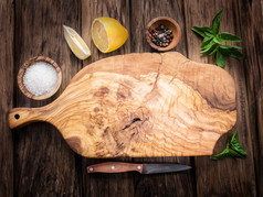 橄榄切菜板和香料放在木制的桌子上.
