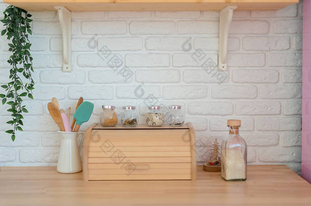 现代化厨房，白色墙壁，木制台面，面包篮，架子和粉色冰箱。生活方式厨房装饰