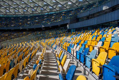 足球奥林匹克运动中的一排排空座位，有黄色和蓝色的长椅