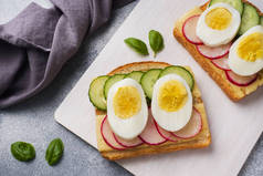 三明治配鸡蛋奶酪、新鲜黄瓜和萝卜。概念健康早餐.