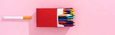 五颜六色的蜡笔在香烟包装和香烟粉红色，吸烟概念全景拍摄