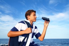 男孩少年双筒望远镜探险家在蓝色海滩