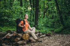 女孩与背包放松在树林中的日志