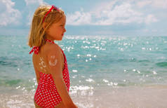 海滩防晒-肩上涂防晒霜的小女孩