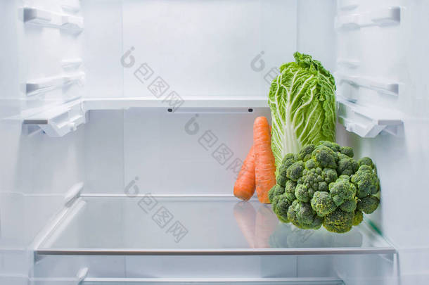 将新鲜西兰花、北京<strong>卷心菜</strong>和胡萝卜放在空冰箱中，复制空间