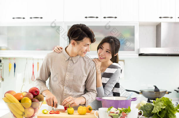 幸福的年轻夫妇在厨房做饭