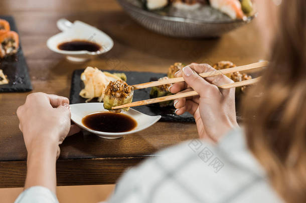 餐厅内妇女用筷子浸寿司的部分观点