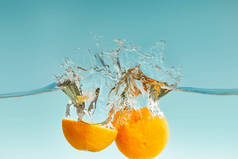 成熟的切橙落水，蓝色背景上飞溅
