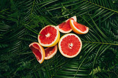 棕榈叶上新鲜葡萄柚片的顶部视图