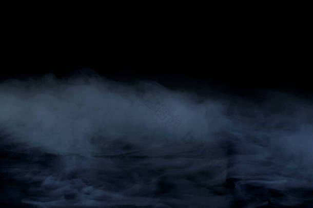真正的烟雾在黑色背景照片上。干冰浓烟.