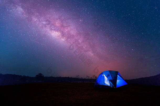 露营蓝色的帐篷在<strong>银河系</strong>的<strong>夜空</strong>下闪闪发光。