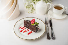 近距离观看美味巧克力蛋糕与覆盆子和一杯茶在桌子上