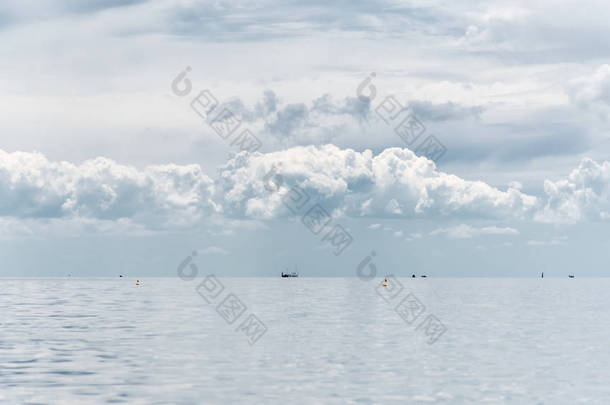 清晨海景--多云的天空上空, 远处是一片寂静的海面, 浮标和轮船