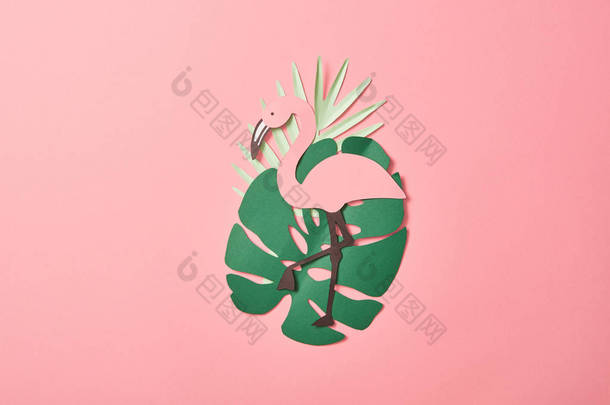 在粉红色背景的绿棕榈叶上<strong>剪纸</strong>火烈鸟的顶视图