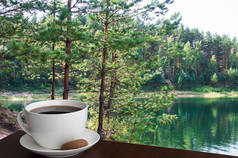 在绿松石湖畔的小管子树旁，一杯加曲奇的咖啡杯。拉脱维亚夏季森林，有管道树
