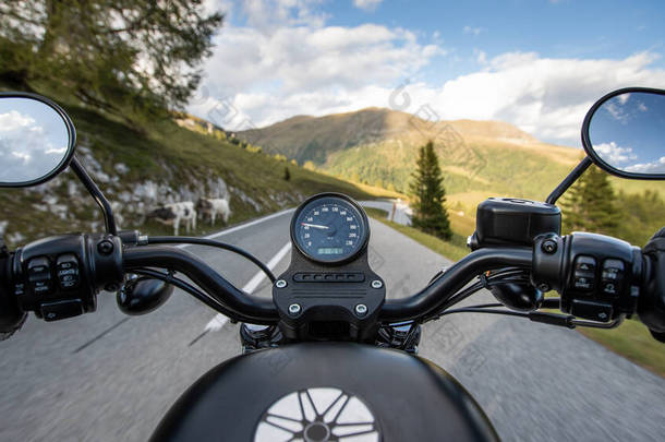司机骑摩托车在山中的沥青路面上，方向盘的细节.