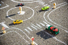 玩具汽车的红色绿色蓝色的道路上粉刷着黑色沥青。交通规则的困难概念.