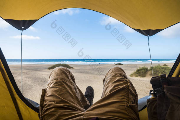 把人安顿在帐篷里，享受与海滩和大海一起自由露营的放松和冒险的观点