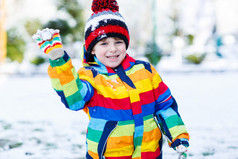 在丰富多彩的冬天的衣服出去玩堆雪人，小男孩