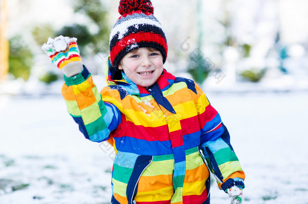 在丰富多彩的冬天的衣服出去玩堆雪人，小男孩