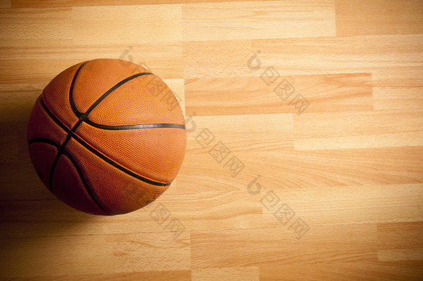 官方的橙色的球在硬木篮球场上 