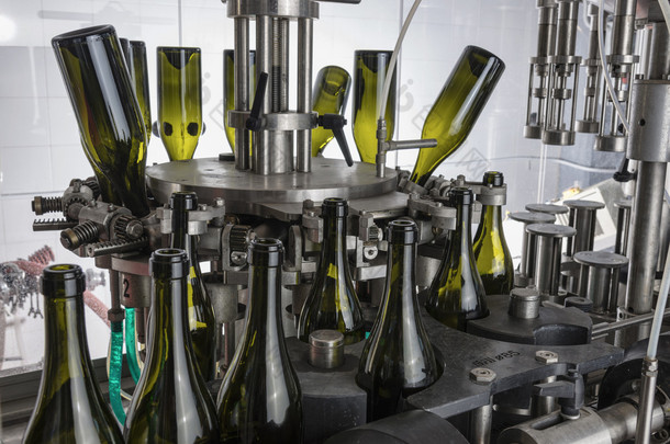 意大利，西西里岛，葡萄酒瓶准备洗和充满酒由某葡萄酒厂工业机器