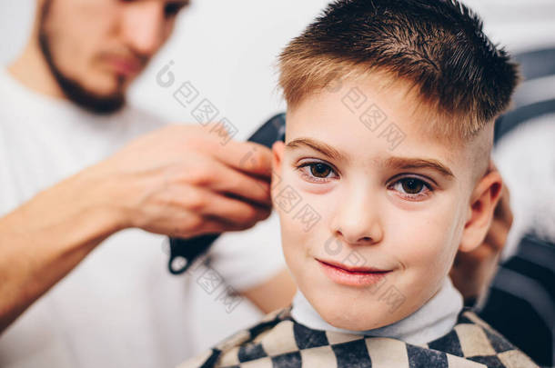 理发师在美发店打扮可爱的小男孩