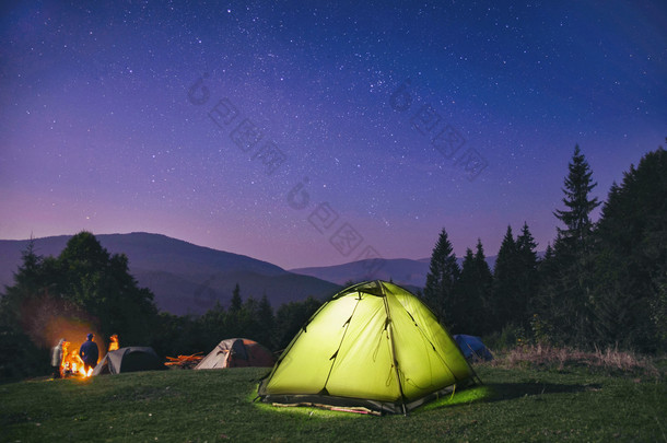 照明的绿色帐篷，晚上森林，喀尔巴阡，乌克兰在星空下 