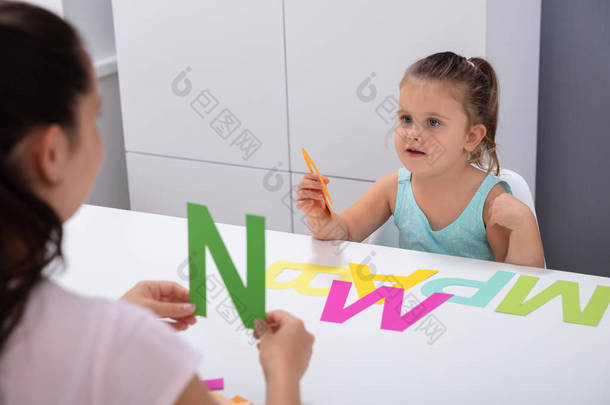 可爱的小女孩在言语治疗师办公室学习字母P
