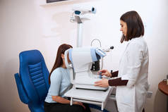 眼科医生正在对一台自动折射器进行眼科检查