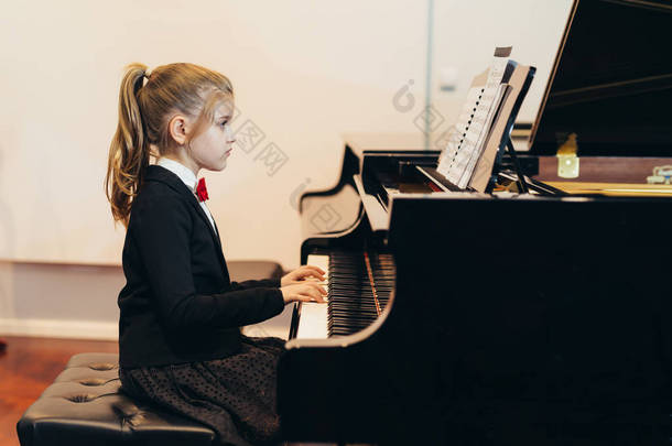 漂亮的小女孩在学弹钢琴