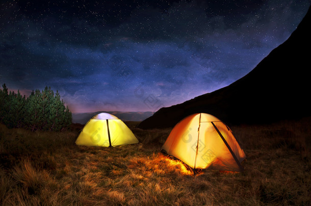 在夜晚的星空下照明黄色野营<strong>帐篷</strong>